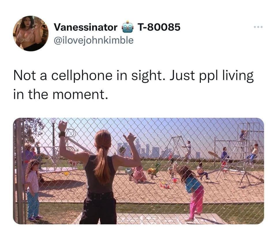 A woman stands at a chain-link fence looking at kids playing in a park, captioned “Not a cellphone in sight. Just ppl living in the moment.”
