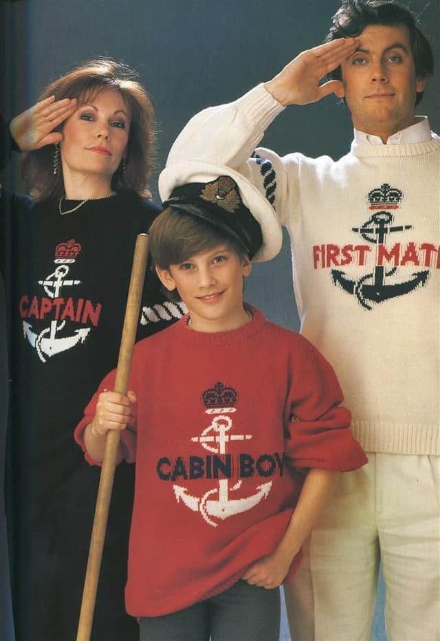 A family trio wearing matching nautical sweaters labeled “Captain,” “First Mate,” and “Cabin Boy,” all saluting.