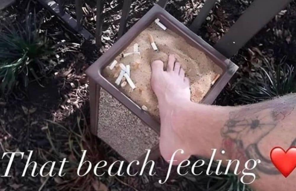 Foot stepping into a cigarette-filled ashtray labeled as beach feeling