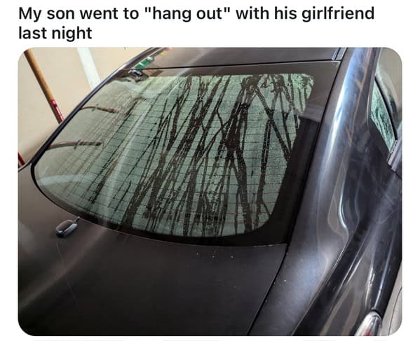 Steamy handprints streak across a car’s rear window overnight.