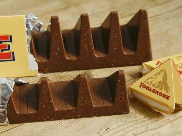 A classic shrinkflation example showing the new Toblerone chocolate bar with huge gaps between peaks.
