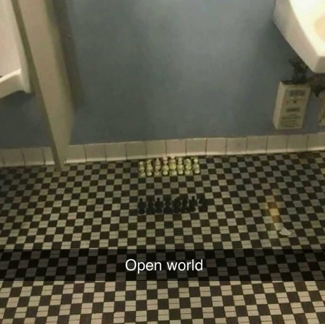 A funny photo of a bathroom where someone has set up a game of chess on the checkered floor tiles.