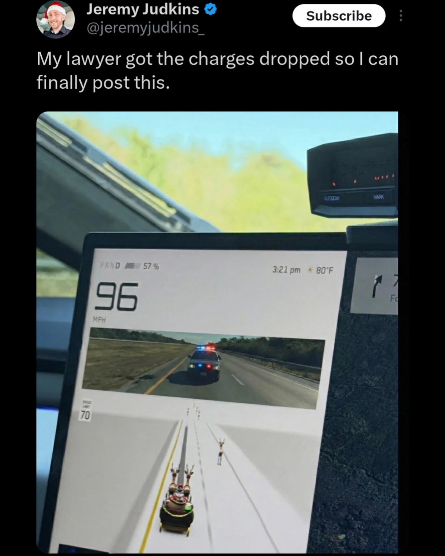 A funny meme showing a Tesla screen displaying reindeer while actually being pulled over by police.