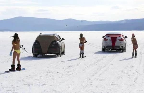 Women in bikinis skiing behind a car on a frozen lake funny pic.