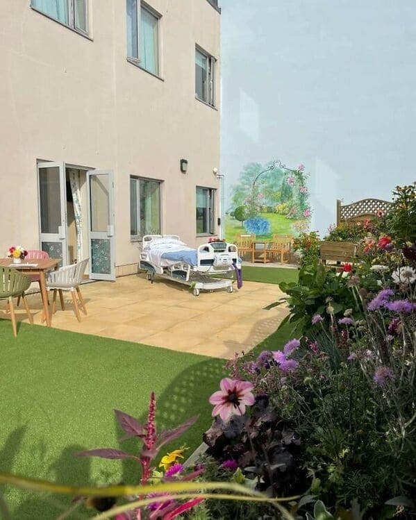 A liminal space creepy hospital bed sitting alone on an outdoor patio with a mural.