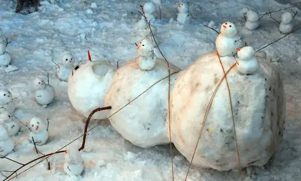 Giant snowman tied down by tiny snowmen like Gulliver.