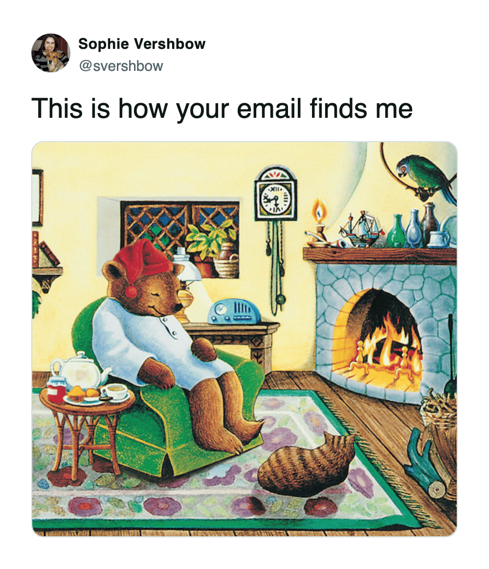 Illustration of cozy bear sleeping in pajamas by fireplace meme about email availability.
