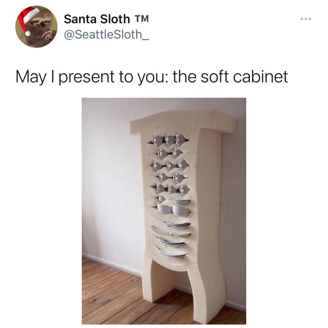 A tall foam block with horizontal slits holding various plates and bowls, titled "the soft cabinet."