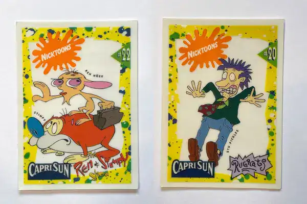 rare nostalgic collectible featured in these 90s pictures showing two Capri Sun promotional window clings, one featuring Ren and Stimpy and the other showing Stu Pickles from Rugrats.