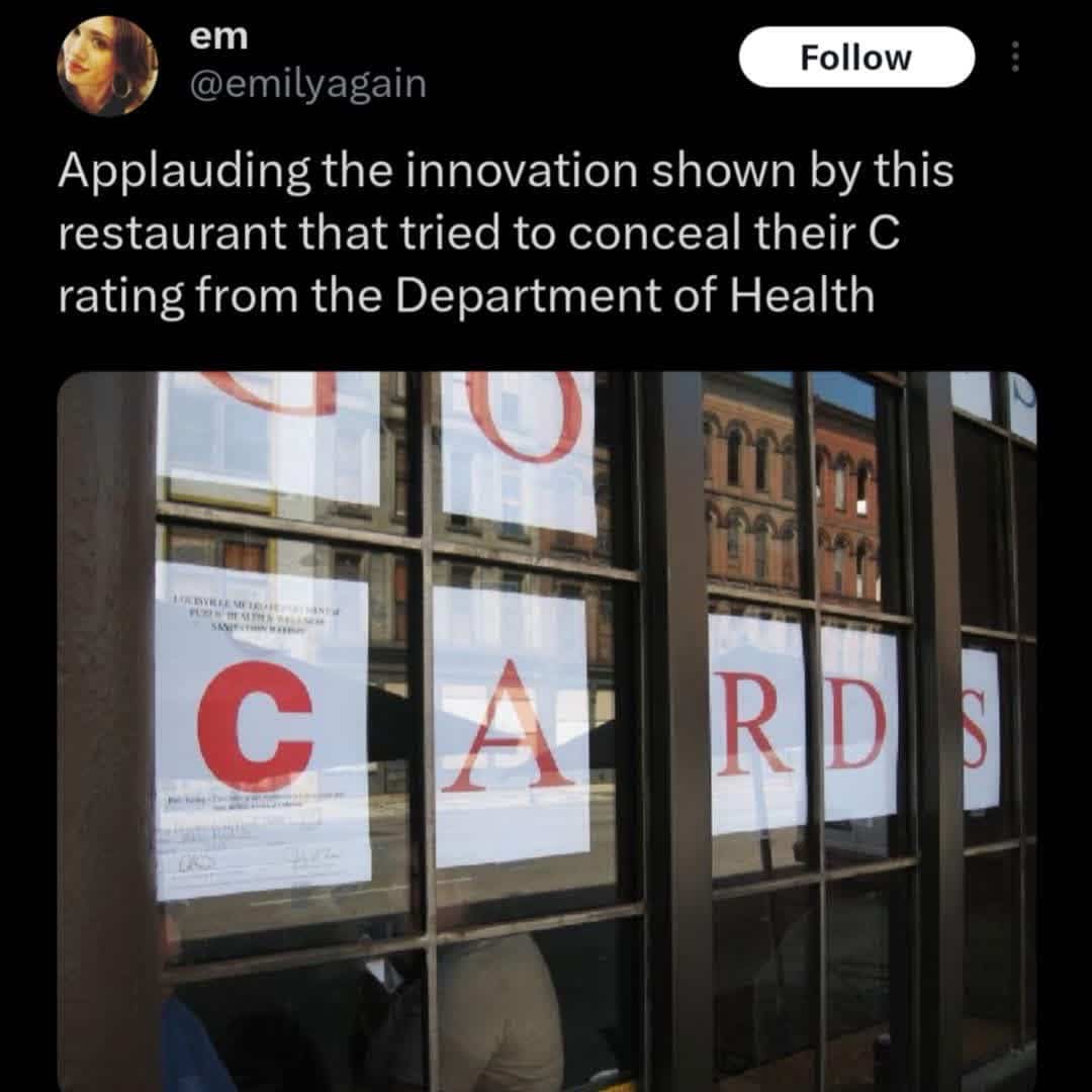 Restaurant window displaying a large sign for CARDS to cleverly hide a C health department inspection rating grade.