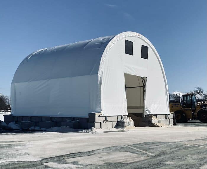 massive, architectural example of inanimate objects with faces showing a large white storage tent with two black square windows and a giant open doorway, looking exactly like a surprised giant ghost.