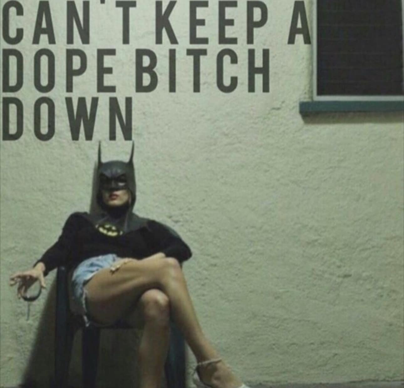 An unbothered, "dope bitch" aesthetic image featuring a woman in denim shorts and a Batman mask lounging in a plastic chair, overlaid with large block text: "CAN'T KEEP A DOPE BITCH DOWN."