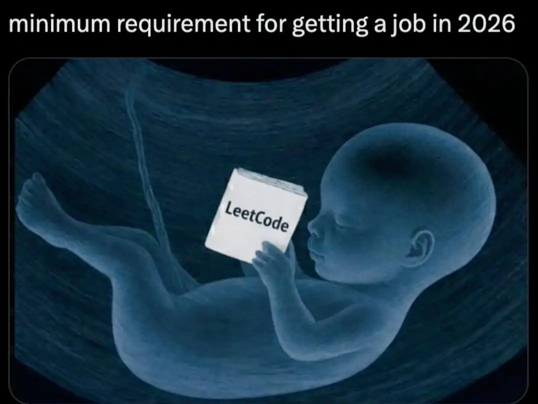 satirical programming meme featuring an ultrasound image of a fetus reading a "LeetCode" book. The text above states: "minimum requirement for getting a job in 2026."
