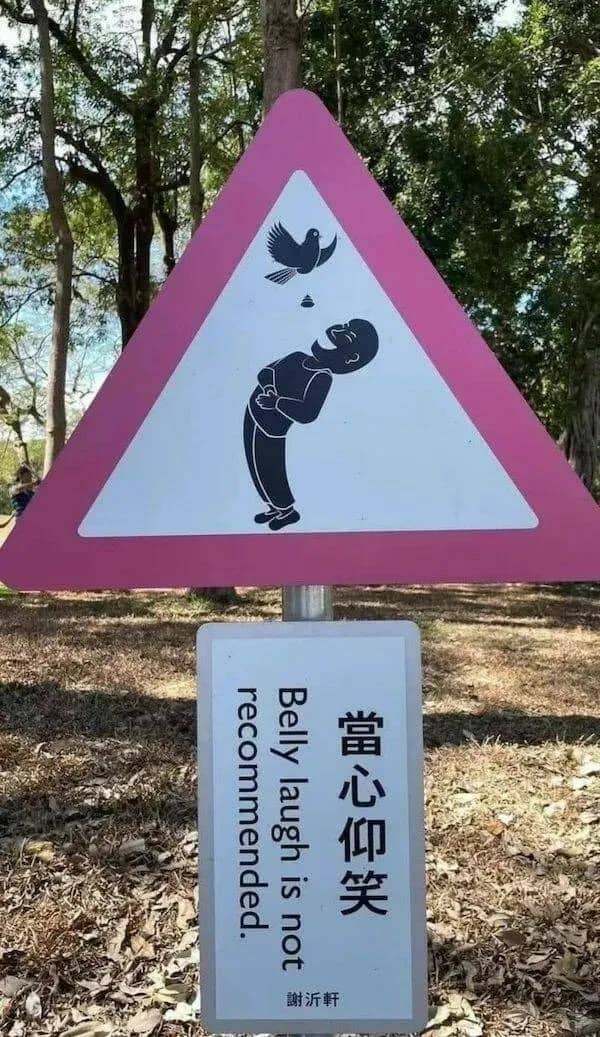 Humorous warning sign showing a bird pooping into a man's mouth with text advising against belly laughs.