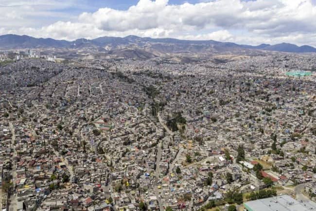 Vast dense informal urban settlement sprawling across hills and valleys in Latin American city