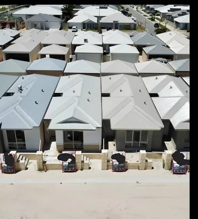 Aerial view of tightly packed identical cookie-cutter suburban homes with zero green space Australia