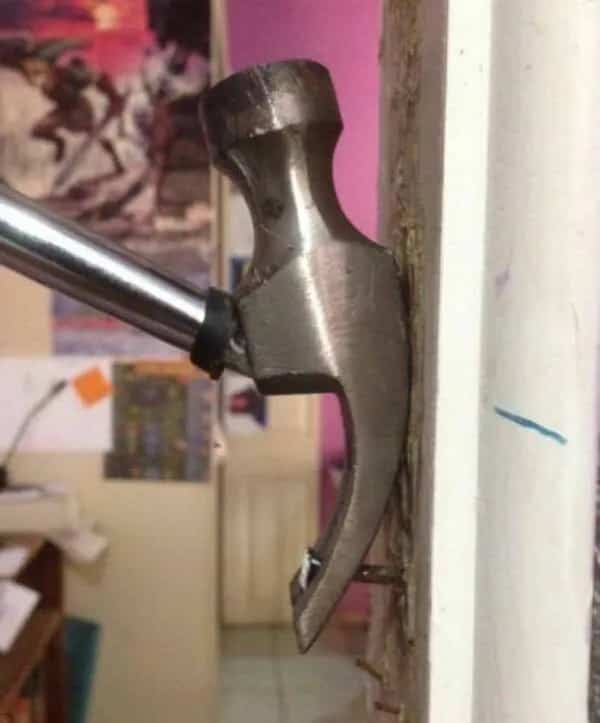 Hammer claw pulling a nail out of a wall at an impossible angle.