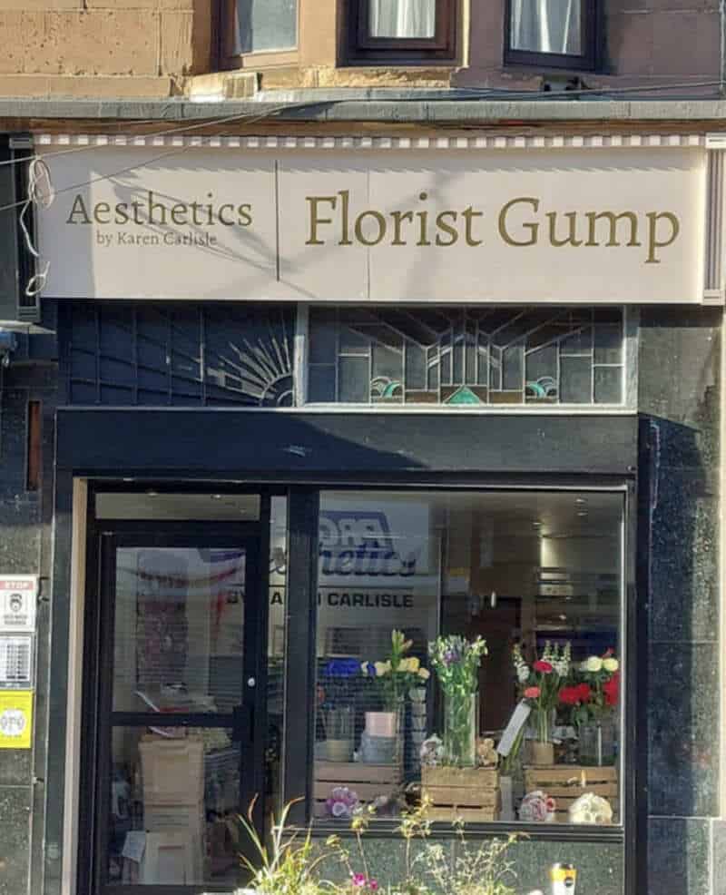 Storefront sign for a flower shop named Florist Gump next to an aesthetics clinic.