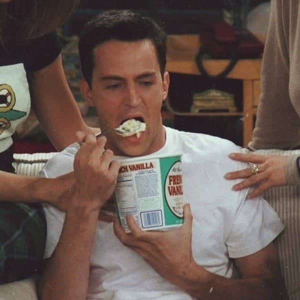 Friends scene of Chandler being spoon-fed ice cream from a tub while friends comfort him