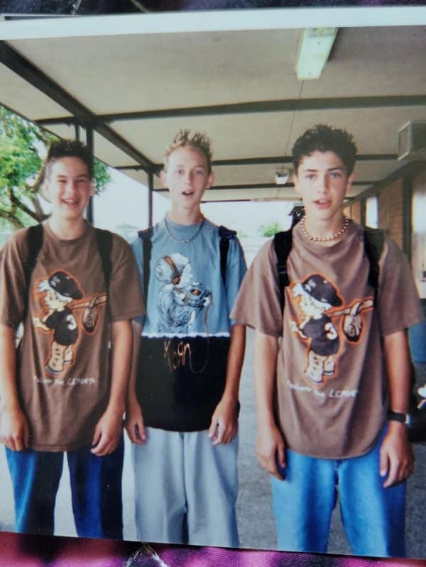 Blunder years photo of three boys in cartoon tees, a Korn shirt and puka shells.