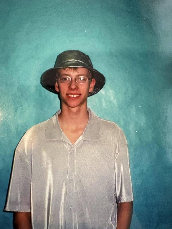 Blunder years snapshot of a smiling teen in a bucket hat and shiny silver shirt.
