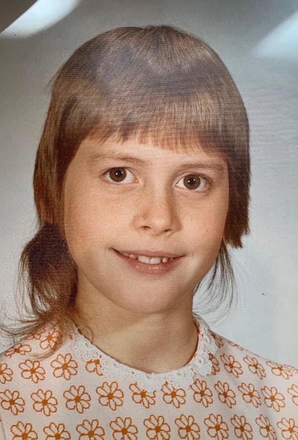 Blunder years picture of a kid with a helmet-shaped shag haircut and a flower-print shirt.