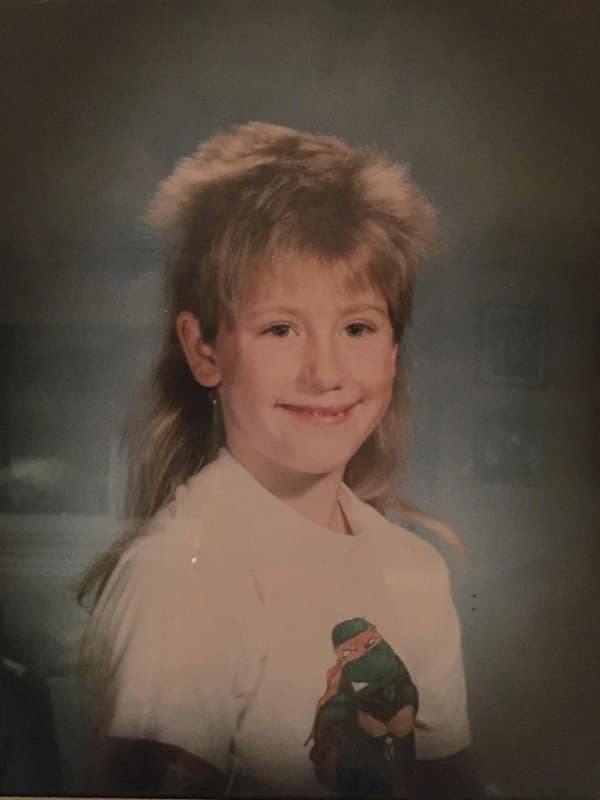 Blunder years portrait of a kid with a full mullet and a Ninja Turtle shirt.