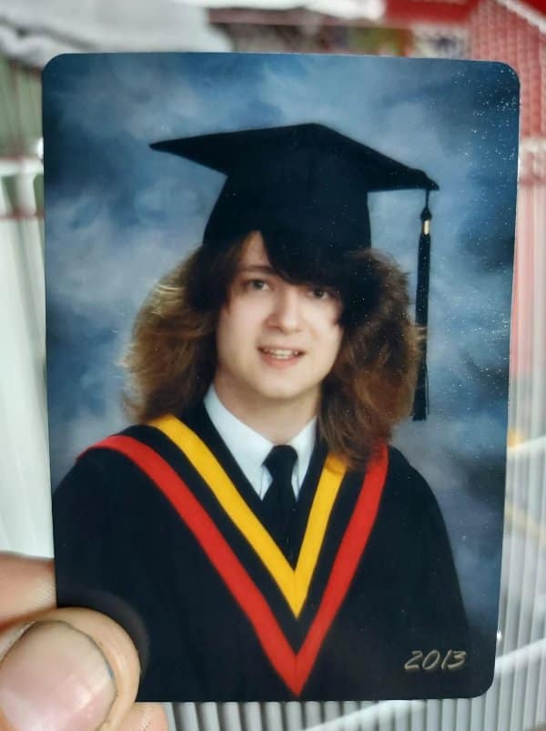 Graduation photo from 2013 of a young man with shaggy side-swept hair under his cap.