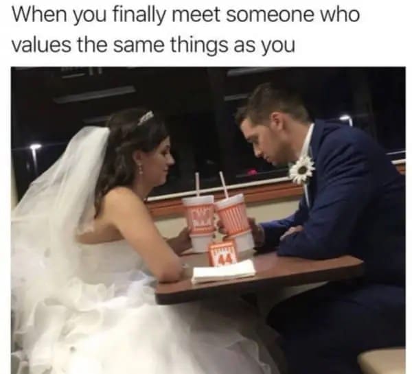Bride and groom in full wedding clothes sharing drinks at a Whataburger booth.