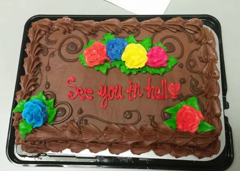Chocolate sheet cake with bright frosting roses and red icing saying see you in hell