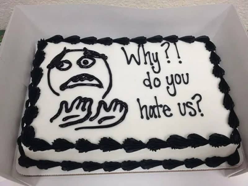 Goodbye cake with a piped rage face asking why do you hate us
