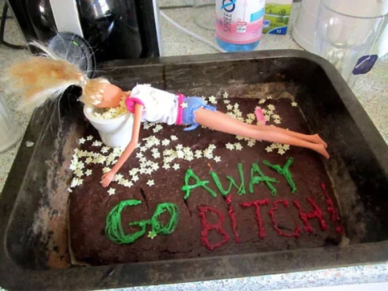 Brownie cake with a doll slumped over a toy toilet and rude farewell icing