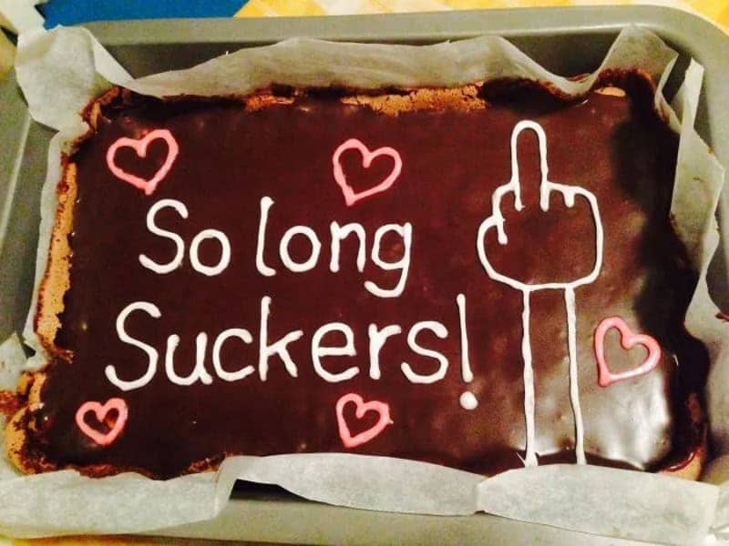 Chocolate cake with hearts, a middle finger drawing, and icing saying so long suckers
