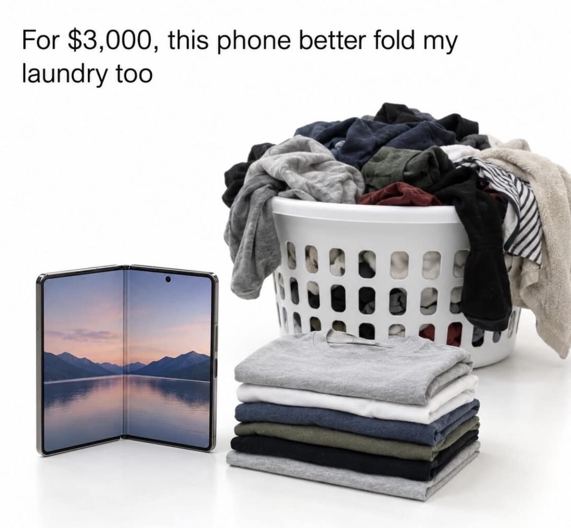 Foldable phone standing next to a laundry basket filled with clothes and neat piles of folded shirts in an iphone duo meme.