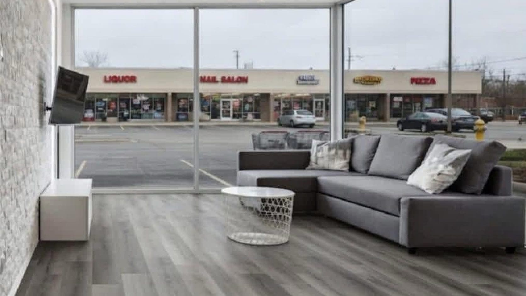 Meme dump featured image of a sleek apartment whose big window looks straight out onto a strip mall parking lot.