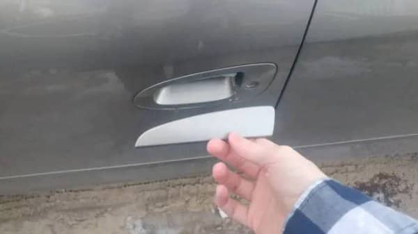 Hand holding a car door handle that snapped off the door, a classic nightmare scenario
