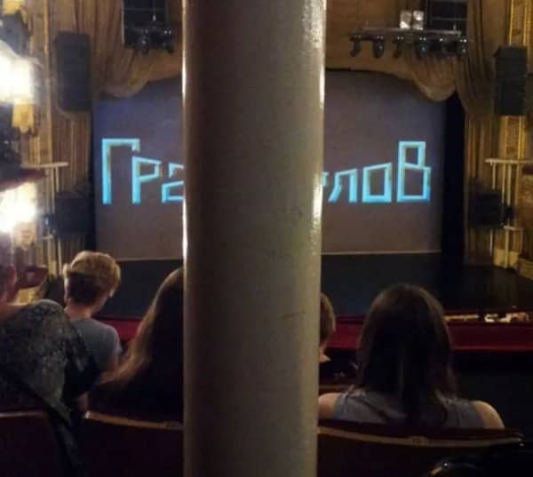 Theater seat view blocked by a giant pillar standing in front of the stage screen