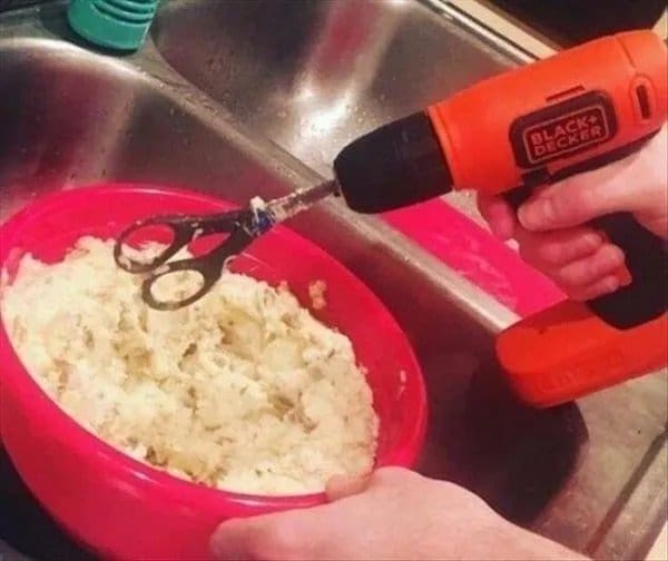 Pair of scissors chucked into a cordless drill to mix mashed potatoes in a bowl.