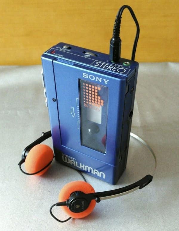 Vintage original metallic blue Sony Walkman TPS-L2 cassette player with lightweight orange foam headphones as retro tech.