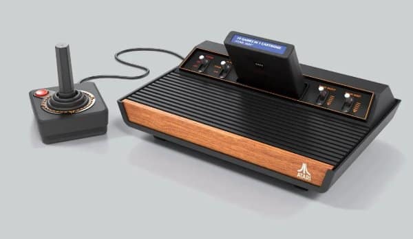 Classic Atari 2600 video game console featuring iconic faux wood-grain paneling and a single-button joystick controller as retro tech.