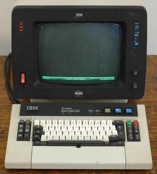 Vintage IBM computer terminal with a green-phosphor monochrome CRT monitor and heavy mechanical keyboard in a retro tech arrangement.