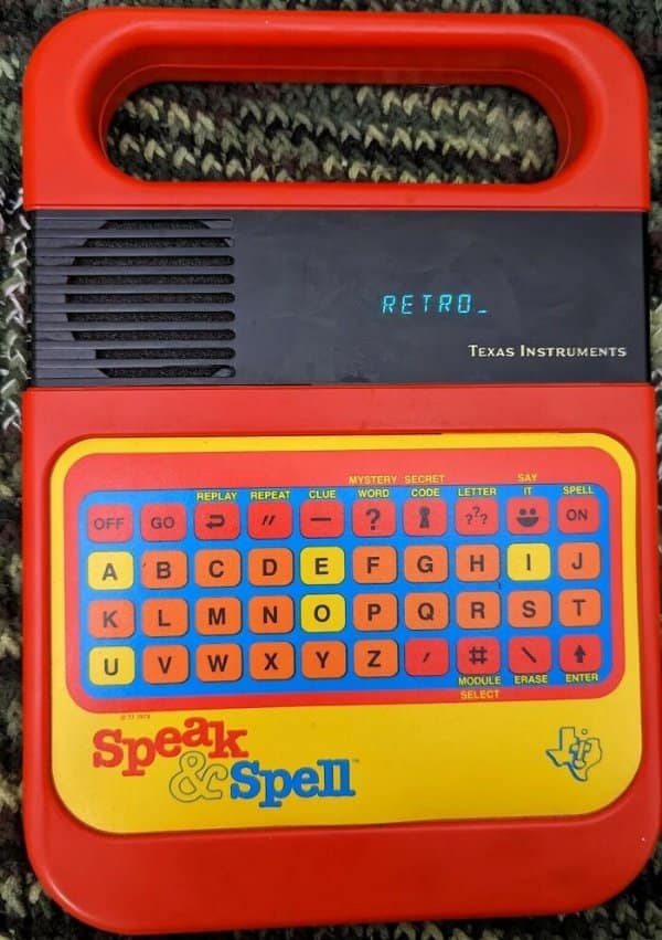 Iconic red Texas Instruments Speak & Spell educational electronic handheld toy displaying text on its screen in a retro tech photo.