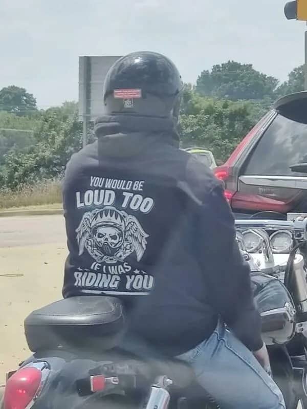 Motorcycle rider wearing a hoodie printed with a crude innuendo slogan about riding
