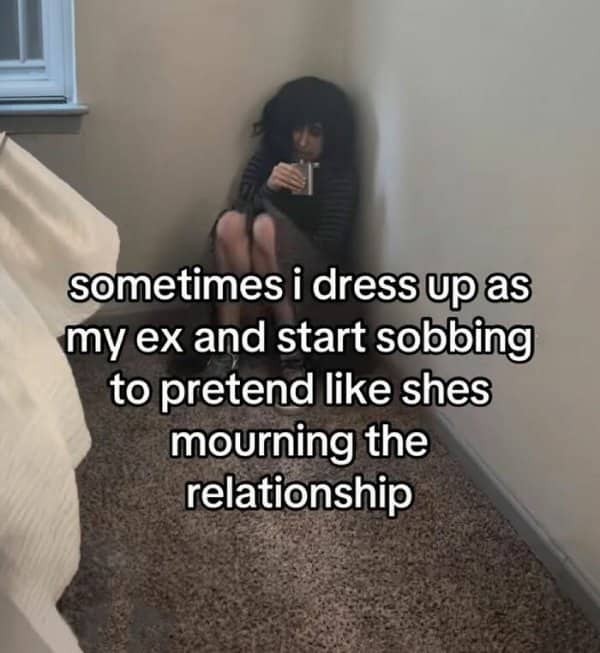 Person crouched in a bedroom corner dressed as their ex, pretending to mourn the relationship