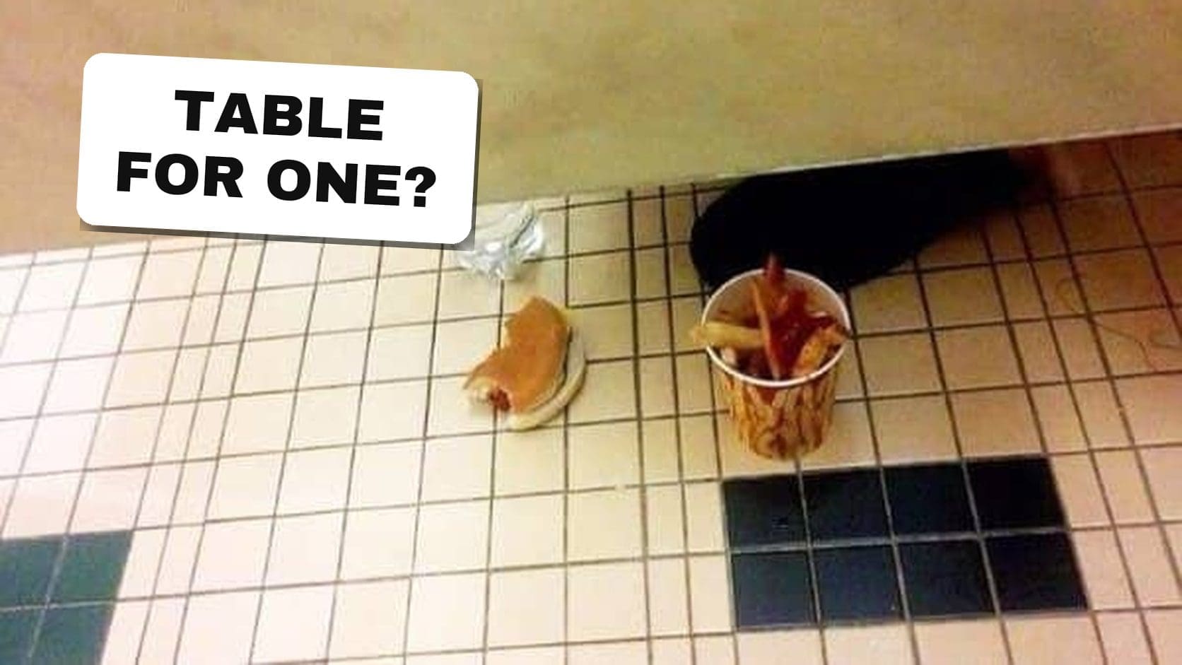 A hot dog and fries left on a bathroom floor beside an occupied stall, pure secondhand embarrassment in one photo.