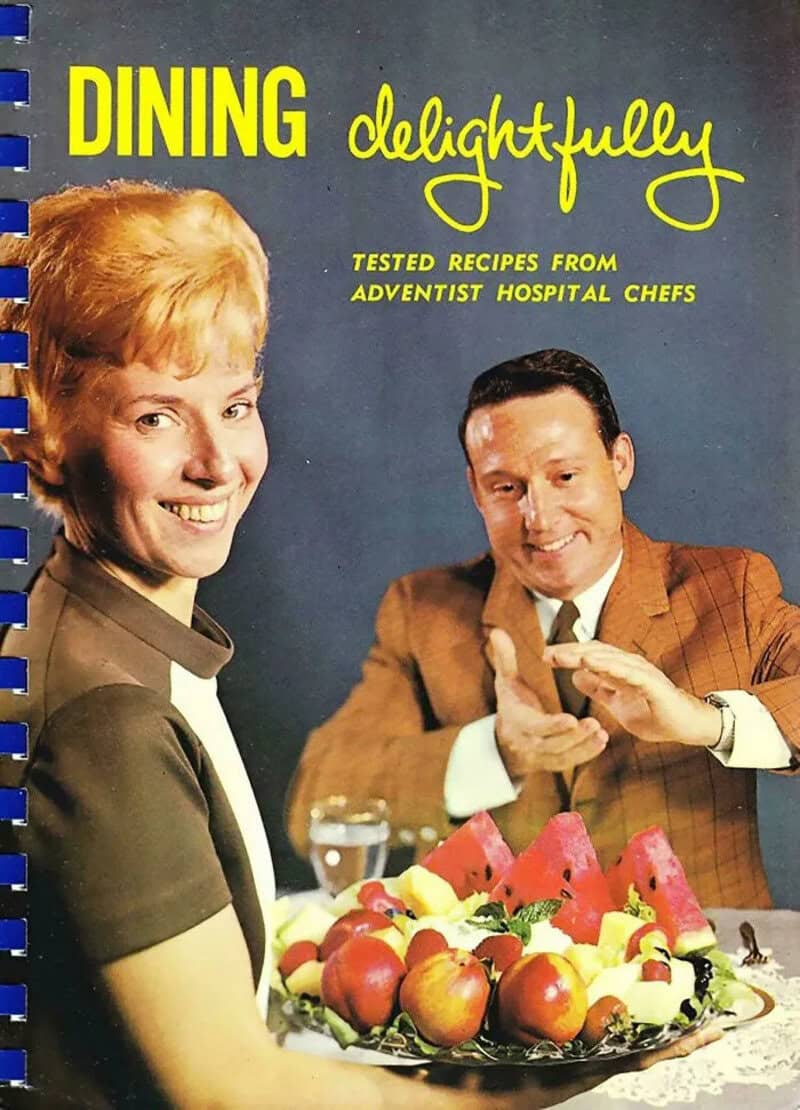 Vintage cookbook Dining Delightfully showing a smiling woman serving fruit to an eager man.