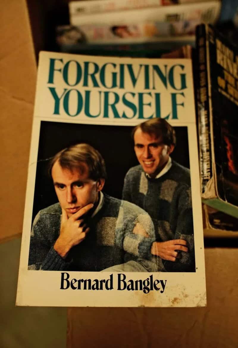 Self-help book Forgiving Yourself showing the same man photographed twice in matching sweaters.