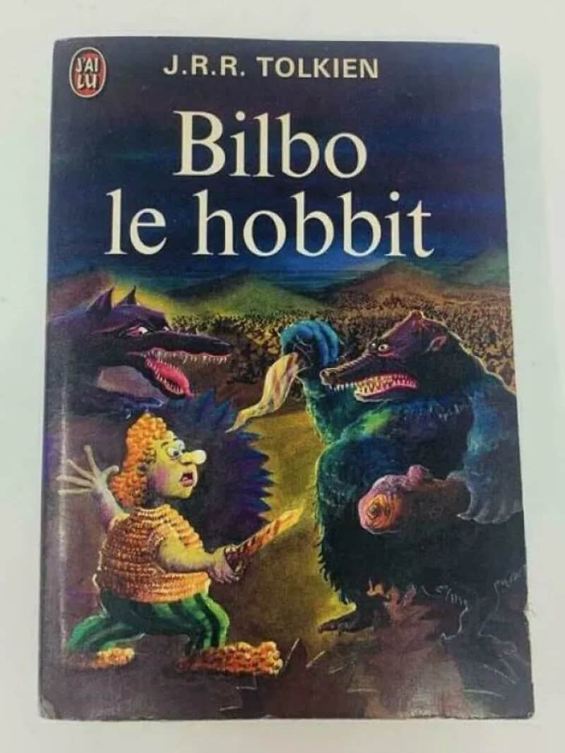 French edition of Bilbo le Hobbit with a startled cartoon Bilbo facing snarling creatures.