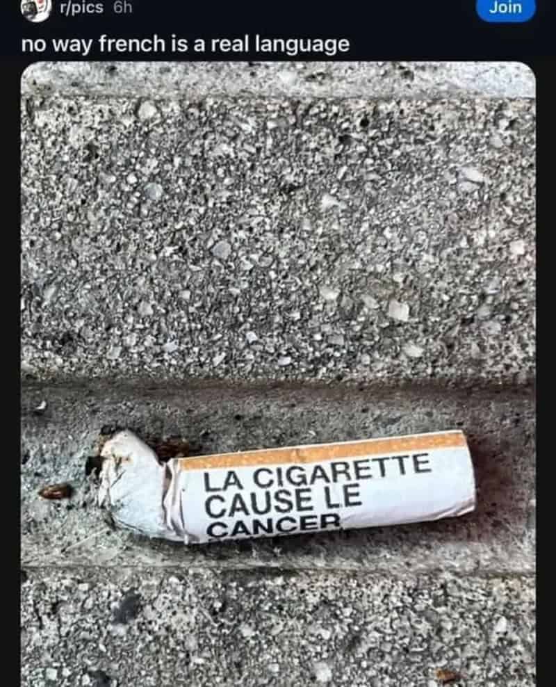 Cigarette butt on concrete printed with the French warning la cigarette cause le cancer