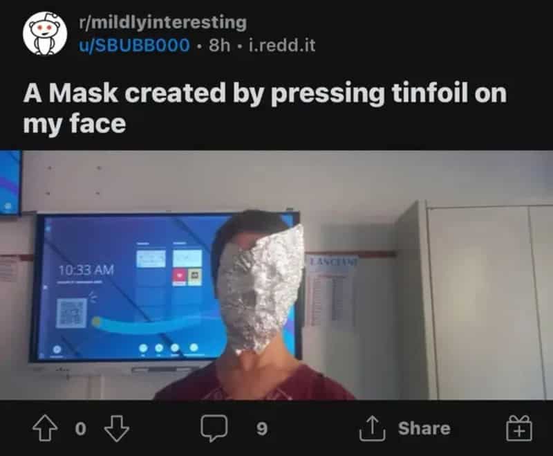 Person wearing a crumpled tinfoil mask pressed into the shape of their face